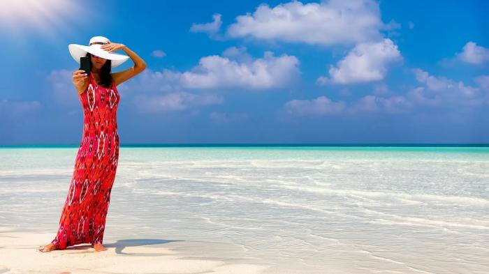 A person in a red dress standing on a beach

Description automatically generated with medium confidence