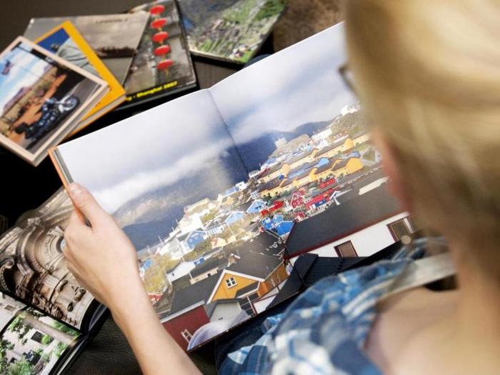 eine Frau schaut sich verschiedene Fotobücher an