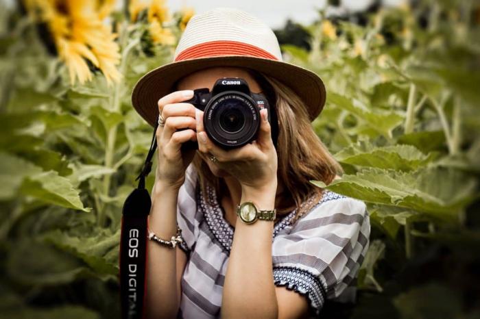 ein Frau macht Fotos in einem Feld